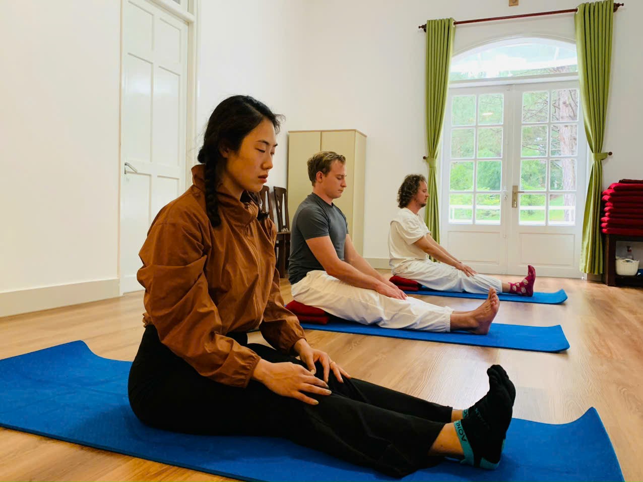 Học viên thực hành seated yoga trong phòng sáng tự nhiên tại Nhà Sức Khỏe